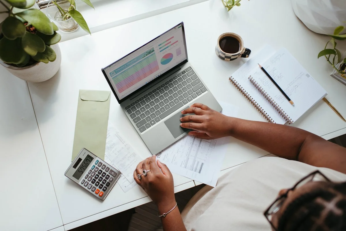 Person comparing different health fund documents at a desk with laptop and calculator