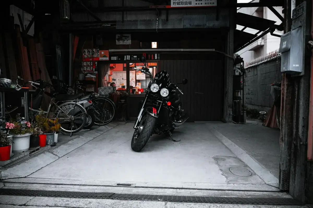 Motorrad und Auto nebeneinander in einer Garage