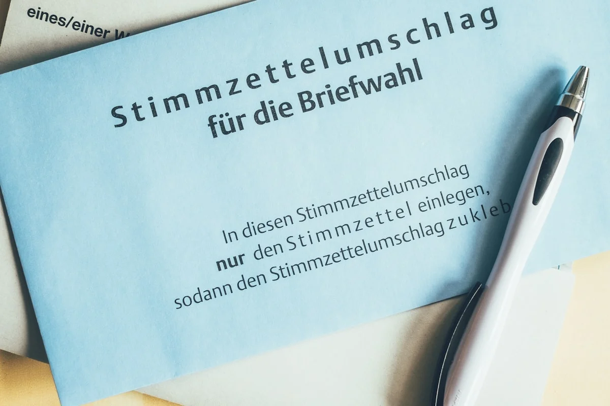 Desk with German insurance paperwork, cancellation letter and calculator for an insurance switch in 2026